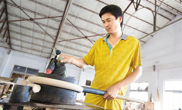 陵水黎族自治縣藤竹工藝品企業(yè)生產(chǎn)車(chē)間，工人用藤制作家具